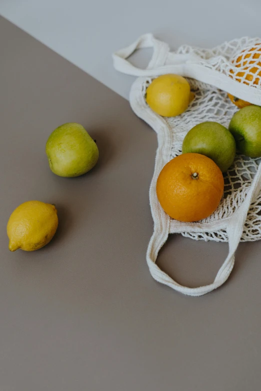 a bag of fruit sitting on top of a table, pexels contest winner, net art, white and orange, thumbnail, cart, grey