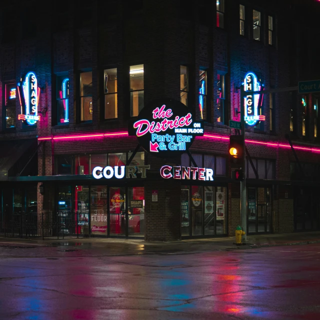 a building with neon signs lit up at night, a photo, by Dan Frazier, pexels contest winner, dunwall city, walton's five and dime, the culture, nighthawks