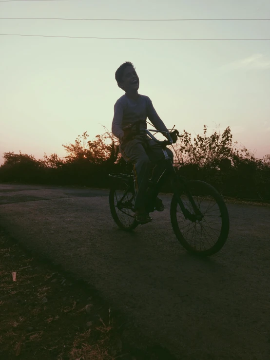 a person riding a bike on a dirt road, in the evening, profile image