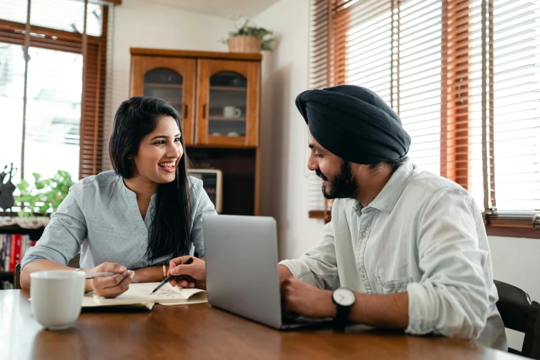 a man and a woman sitting at a table with a laptop, a screenshot, inspired by Manjit Bawa, pexels contest winner, teaching, 9 9 designs, with a happy expression, profile image