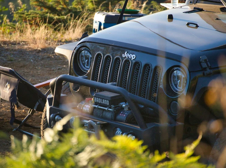 a jeep parked on the side of a dirt road, custom headlights, outdoors setting, profile image, close up photo