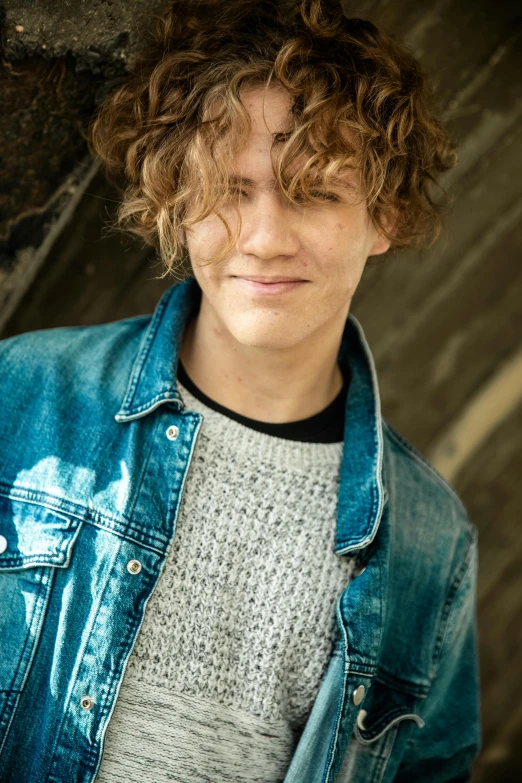 a young man with curly hair wearing a denim jacket, connor hibbs, light brown messy hair, jc park, silver curly hair