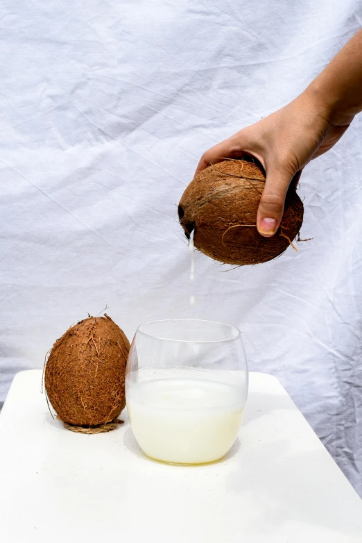 a person pouring coconut milk into a glass, by Nicolette Macnamara, unsplash, renaissance, on clear background, background image, malaysian, hay