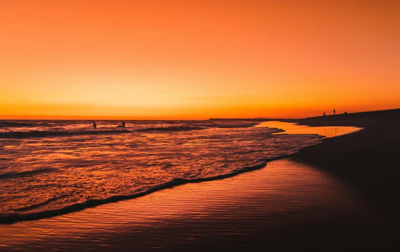 a couple of people standing on top of a beach next to the ocean, pexels contest winner, romanticism, gradient orange, glowing red, california coast, thumbnail