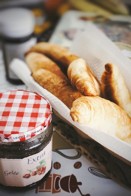 a basket of bread and a jar of jam on a table, baking french baguette, bixbite, extra wide, diner