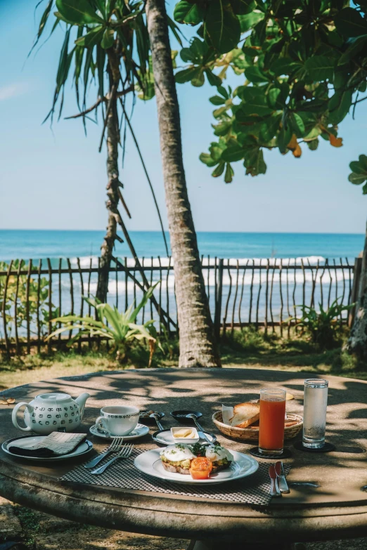 a table that has a plate of food on it, by Sebastian Vrancx, unsplash, beach and tropical vegetation, breakfast, coffee, sri lankan landscape