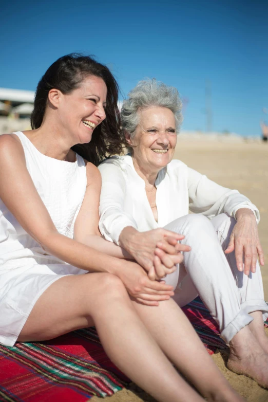 two women sitting on a blanket on the beach, a portrait, pexels contest winner, renaissance, happy italian beach scene, aging, whites, in spain