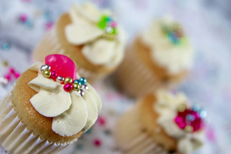 a group of cupcakes sitting on top of a table, by Sylvia Wishart, pexels, with ornate jewelled, colourful close up shot, thumbnail, kek