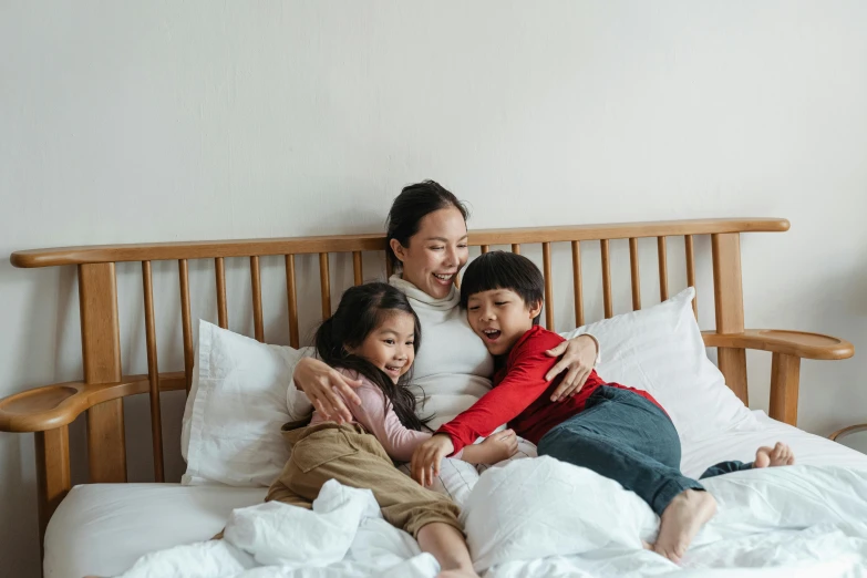 a woman and two children laying on a bed, pexels contest winner, asian female, thumbnail, all overly excited, husband wife and son