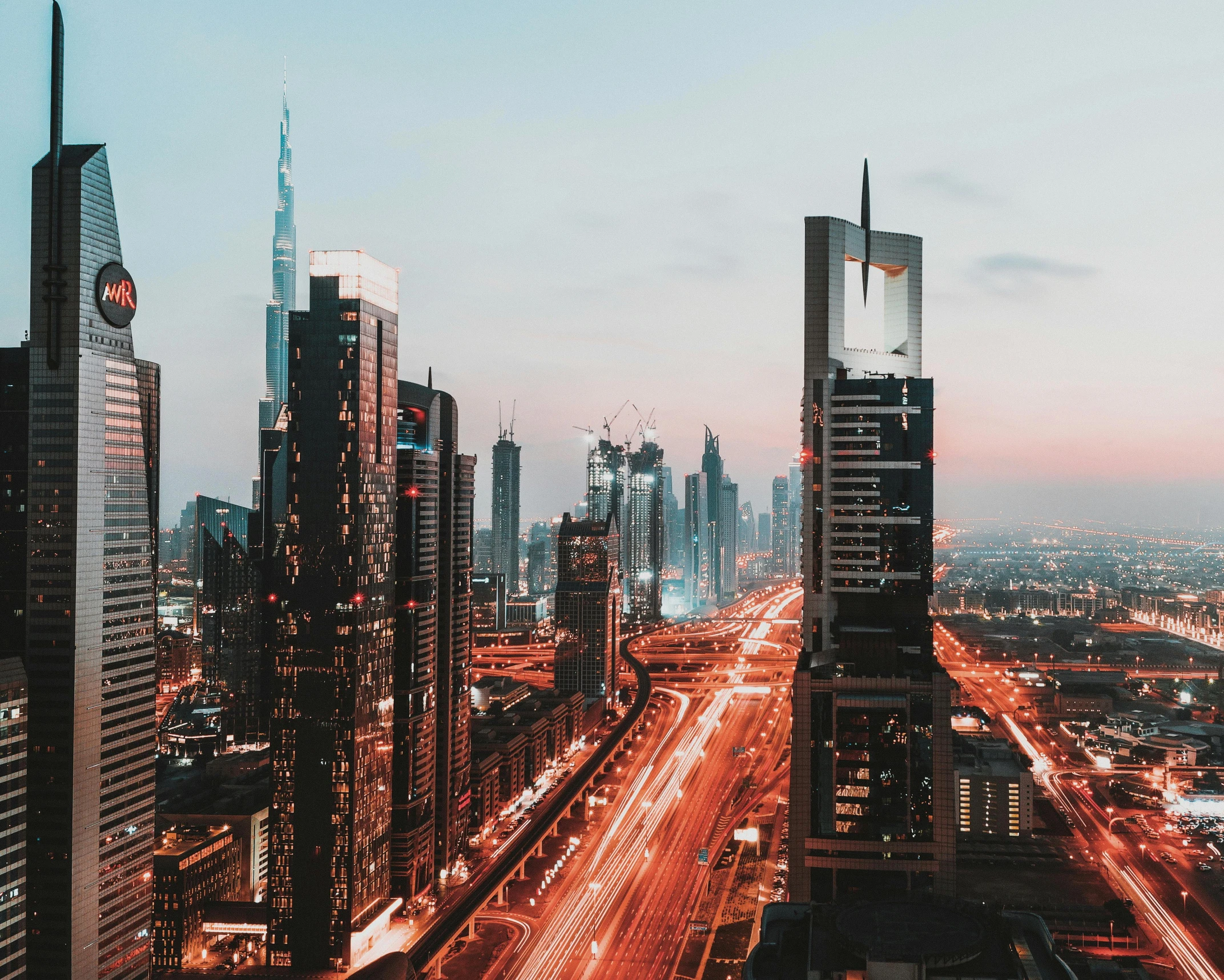 an aerial view of a city at night, an album cover, pexels contest winner, hurufiyya, sheikh mohammed ruler of dubai, youtube thumbnail, skyline view from a rooftop, dusk on a city street