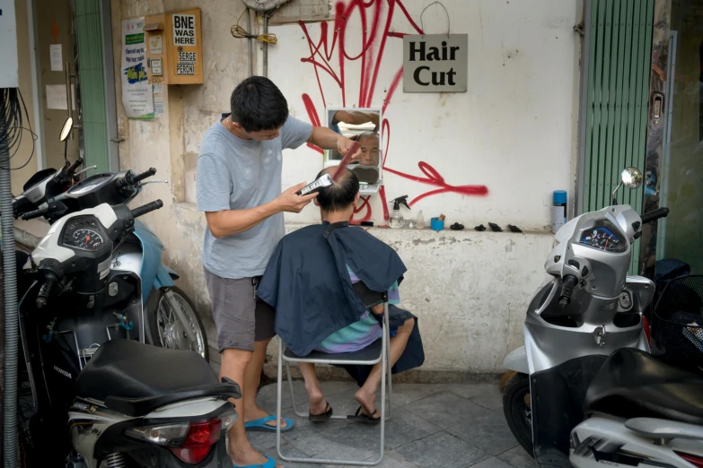 a man cutting another man's hair in a barber shop, a photo, by Kanbun Master, temporary art, vietnam, view from the streets, 🦑 design, half length