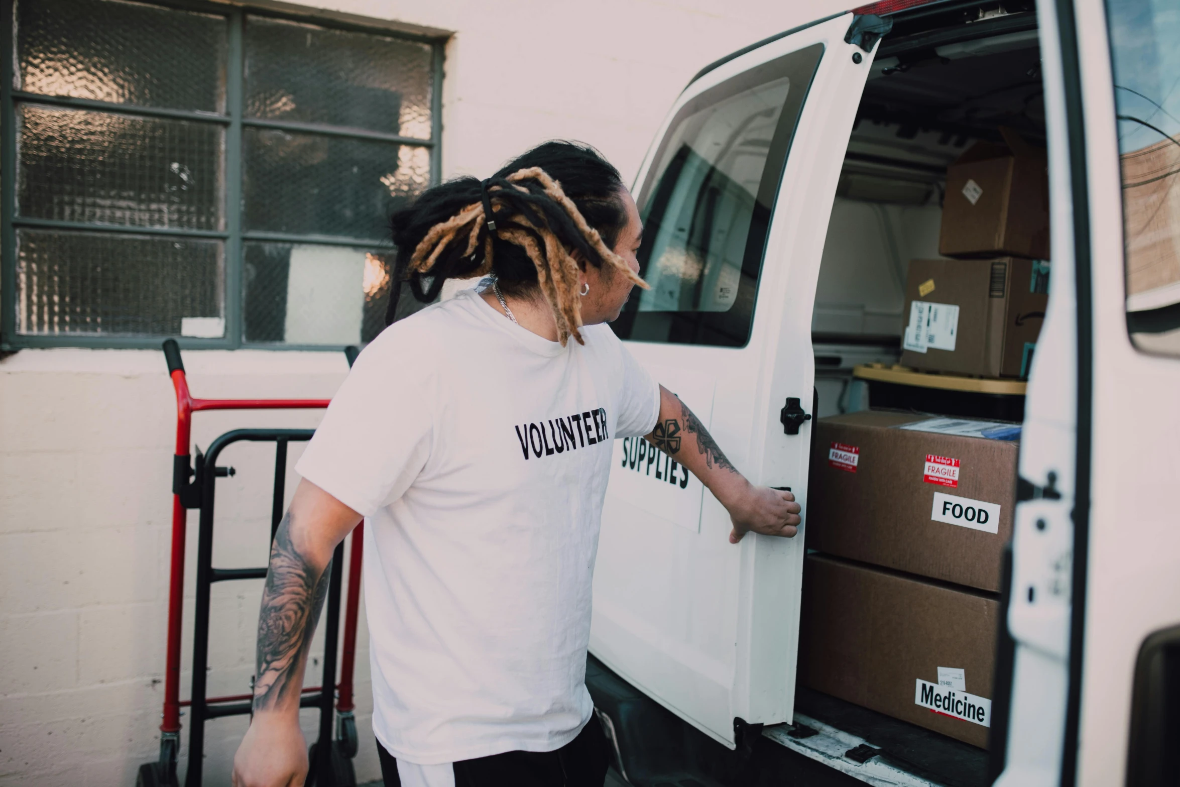 a man with dreadlocks loading boxes into a van, pexels contest winner, teddy fresh, yoh yoshinari, ::