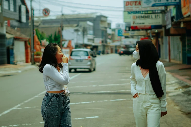 a couple of women standing next to each other on a street, trending on pexels, happening, south jakarta, scene from a movie, white, talking