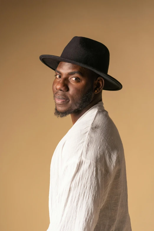 a man wearing a white shirt and a black hat, an album cover, inspired by Theo Constanté, studio portrait photo, actor, obunga, proud looking away