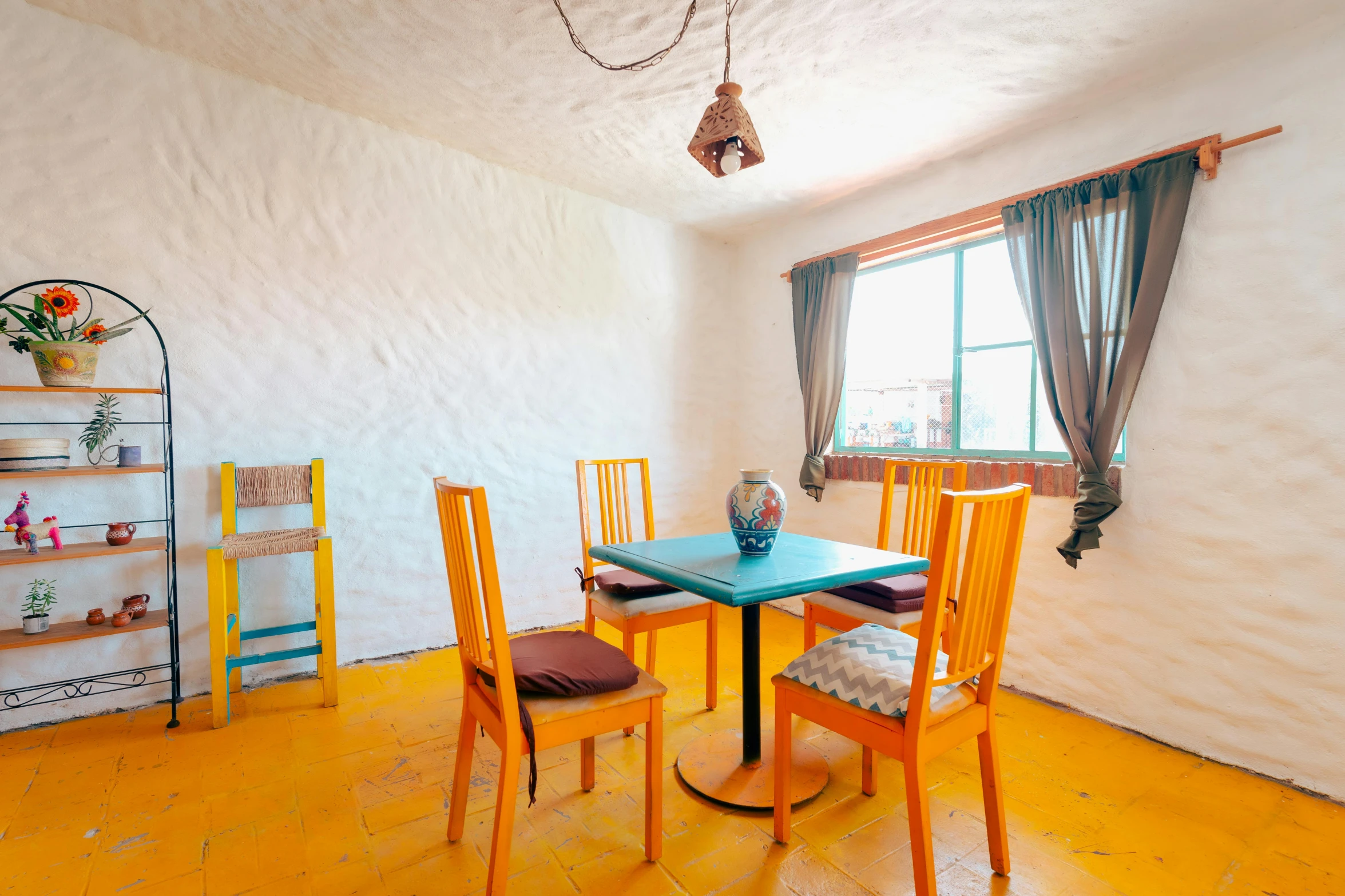 a dining room with a blue table and yellow chairs, unsplash, earthship, square, chilean, background image