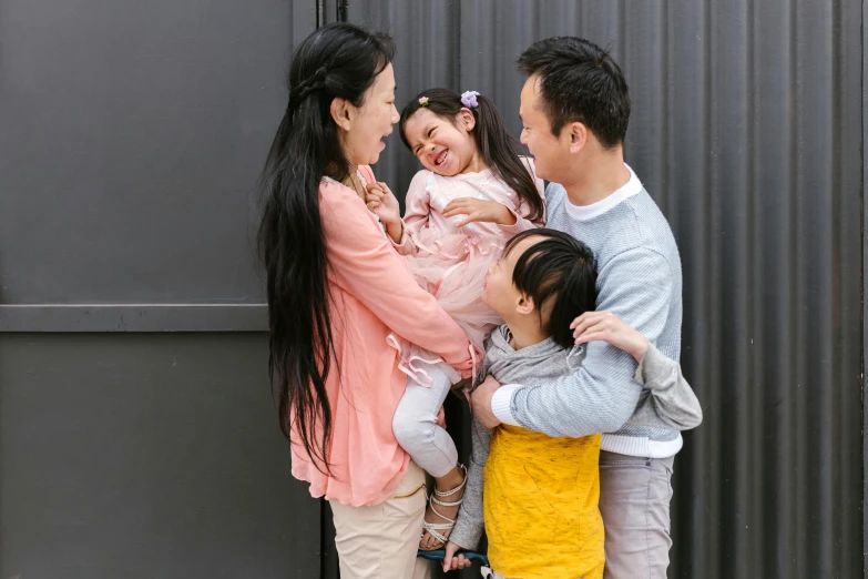 a group of people standing next to each other, a picture, inspired by Cui Bai, pexels contest winner, happy family, giggling, gemma chen, holding each other