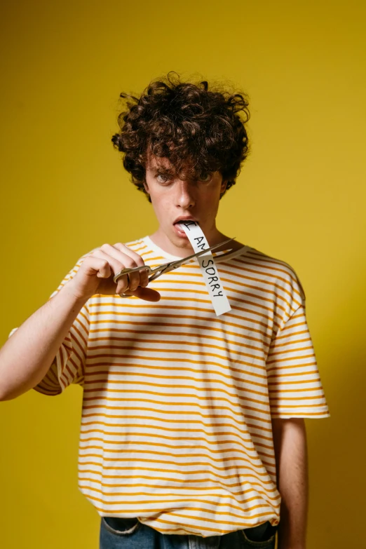 a young man brushing his teeth in front of a yellow wall, an album cover, pexels contest winner, curly bangs, stripes, he has big knives on his belt, caspar david