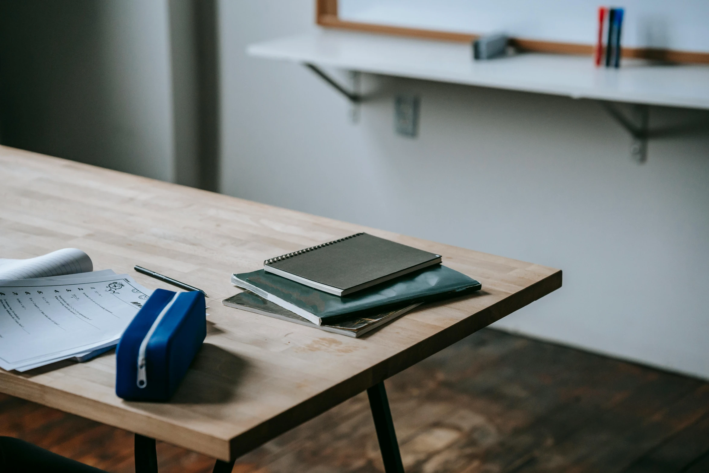 a wooden table topped with books and a phone, ashcan school, whiteboards, background image, uncropped, amanda lilleston