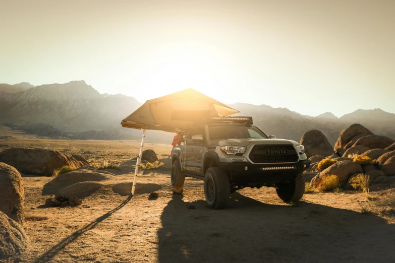 a truck that is parked in the dirt, by Matt Cavotta, unsplash contest winner, auto-destructive art, tent architecture, sunset light, soft top roof raised, avatar image