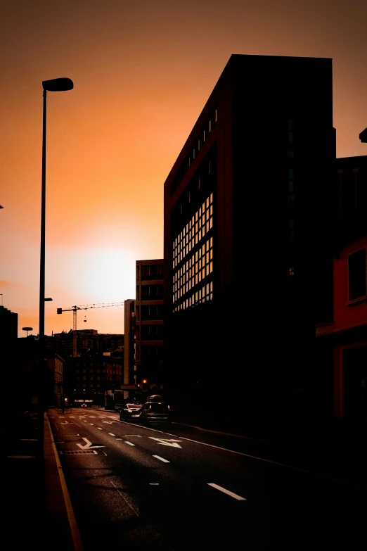 the sun is setting over a city street, by Tobias Stimmer, dramatic lighting - n 9, hannover, ((sunset))