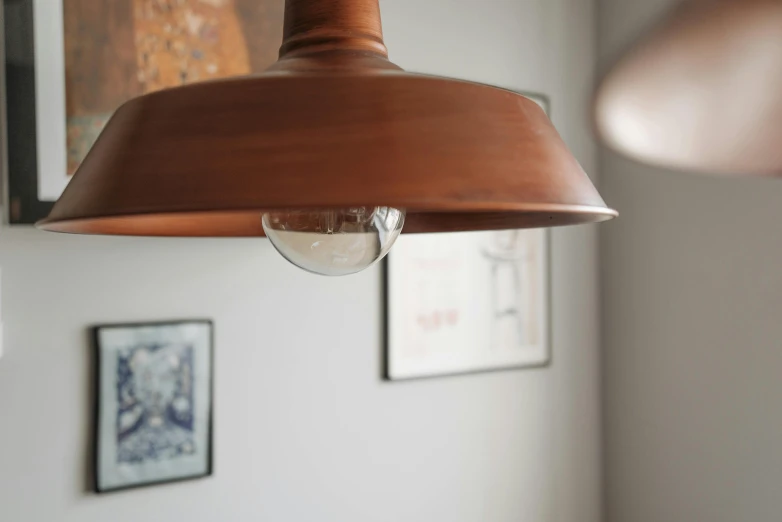 a close up of a light hanging from a ceiling, inspired by Lewis Henry Meakin, light and space, copper patina, 3 light sources, natural light in room, terracotta