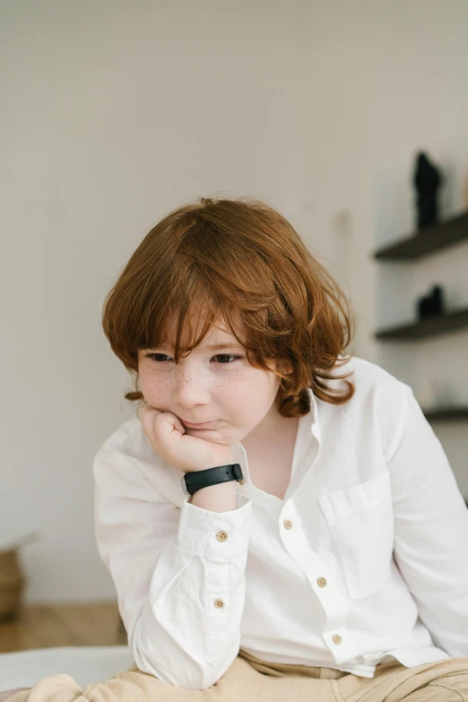 a woman sitting on a bed with her hand on her chin, trending on pexels, red haired teen boy, wearing white shirt, little kid, wears a watch