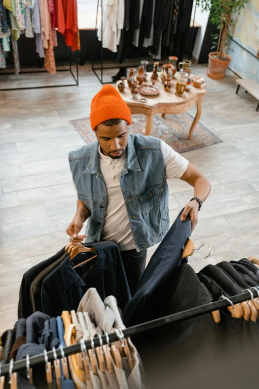 a man sitting in front of a rack of clothes