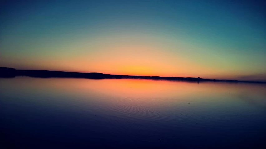 the sun is setting over a body of water, a picture, unsplash, romanticism, blue and orange tones, shot on iphone 6, multi - coloured, medium long shot