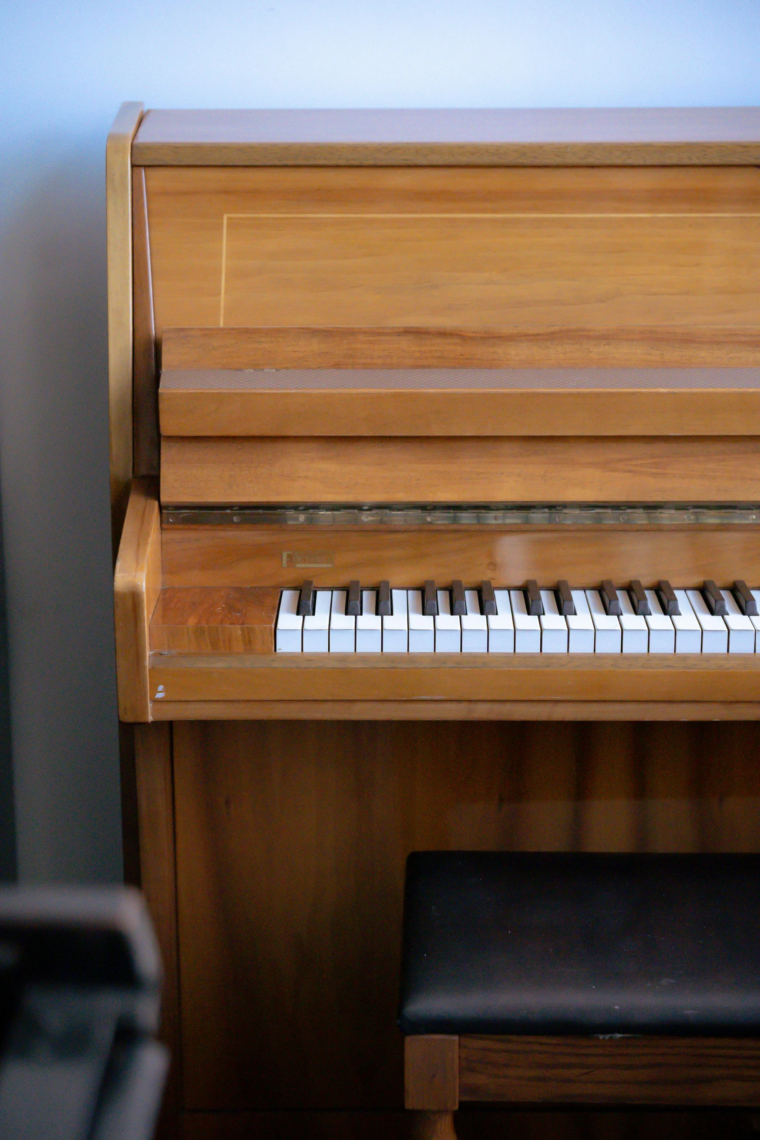 a piano sitting in the corner of a room, on a wooden desk