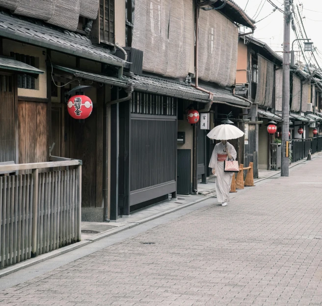 a woman walking down a street with an umbrella, inspired by Watanabe Shōtei, pexels contest winner, wooden houses, gray, empty streetscapes, in a kimono