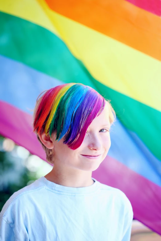 a young boy standing in front of a rainbow flag, trending on pexels, half & half hair dye, colorful]”, educational, wholesome