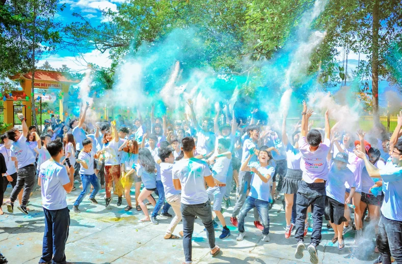 a group of people playing with colored powder, a colorized photo, by Nazmi Ziya Güran, pexels contest winner, white cyan, college party, background image, sunny day time