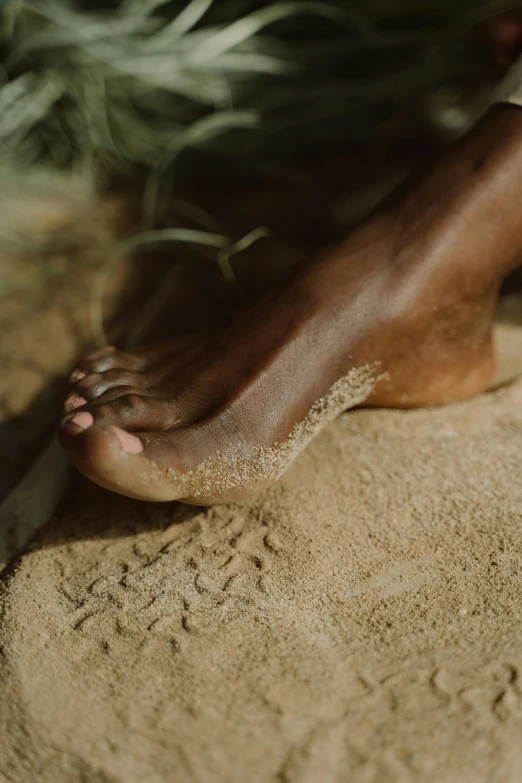 a close up of a person's foot in the sand, by Elsa Bleda, renaissance, unmistakably kenyan, slide show, handcrafted, lightweight