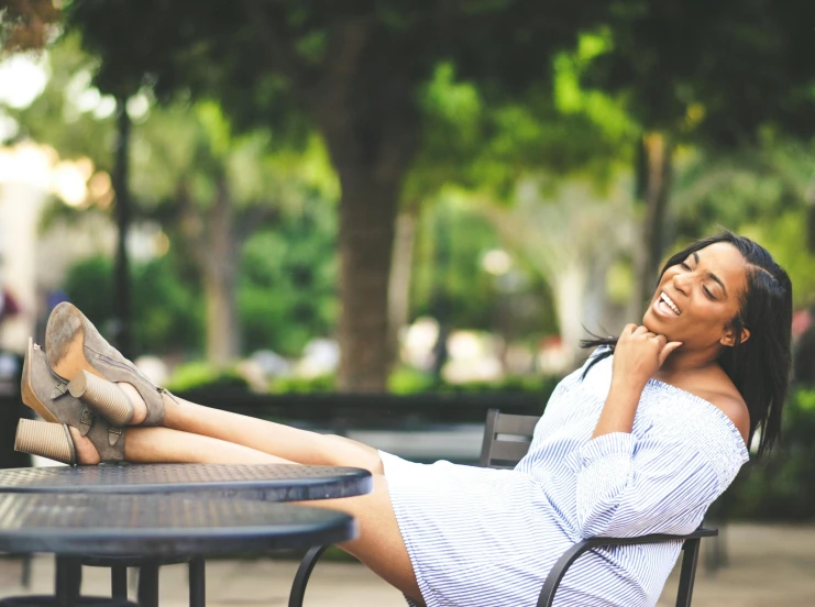 a woman sitting at a table talking on a cell phone, pexels contest winner, having fun in the sun, vanessa morgan, reclining, smiling :: attractive