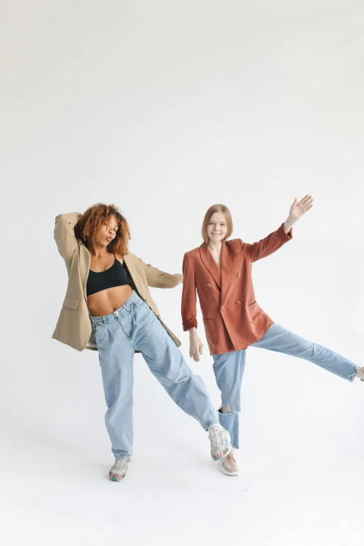 a couple of women standing next to each other, trending on pexels, dynamic dancing pose, baggy pants, professional modeling, brown