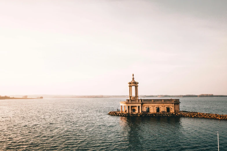 a lighthouse in the middle of a body of water, pexels contest winner, minimalism, greek temple, warm light, indore, 1940s photo