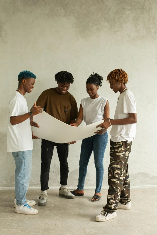 a group of people standing in a room looking at a piece of paper, pexels contest winner, black arts movement, white shirt and blue jeans, building plans, teenagers, transforming