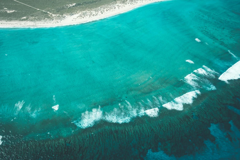 a large body of water next to a sandy beach, an album cover, pexels contest winner, birdseye view, carribean turquoise water, ((waves, australian beach