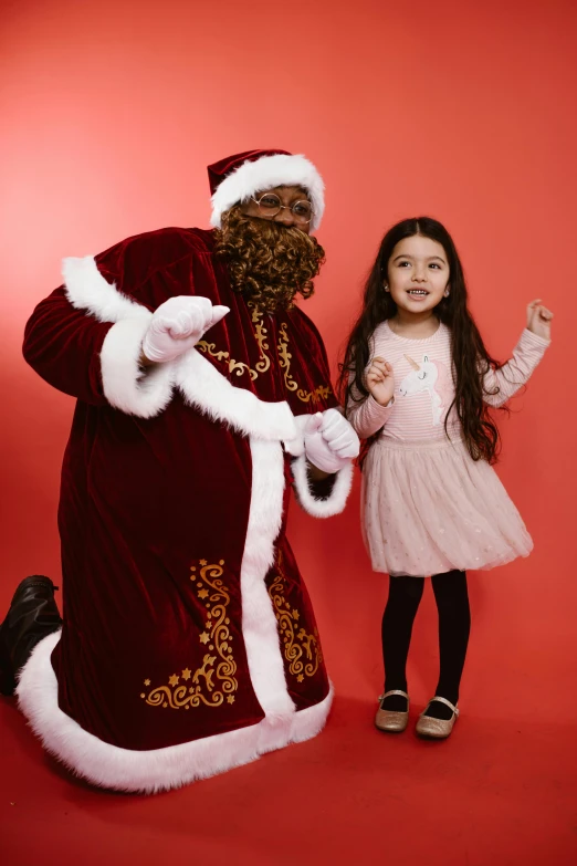a little girl standing next to a man dressed as santa claus, a portrait, pexels, happening, black, a hand, - 6, maroon