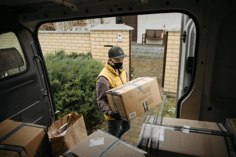 a man loading boxes into the back of a van, pexels contest winner, non-binary, avatar image, seasonal, covid