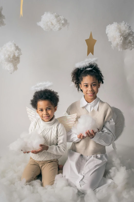 a couple of kids sitting on top of a cloud, an album cover, inspired by Louis Le Nain, pexels contest winner, wearing angel halo, holiday season, indoor picture, varying ethnicities