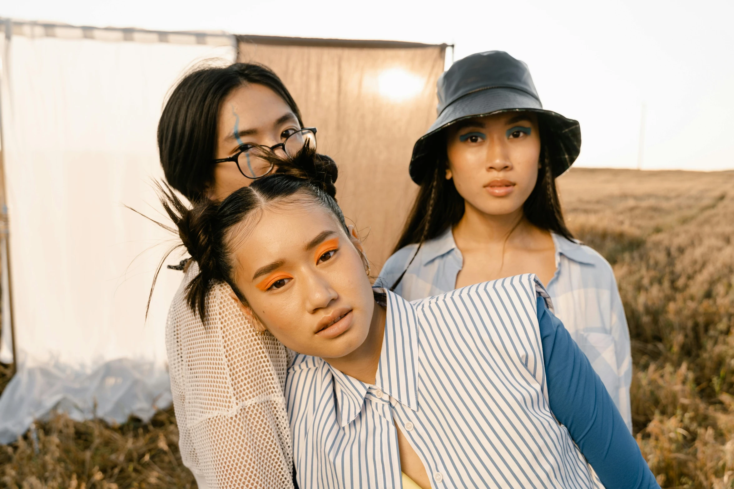 two women standing next to each other in a field, an album cover, trending on pexels, young cute wan asian face, three women, group portrait, milk bar magazine