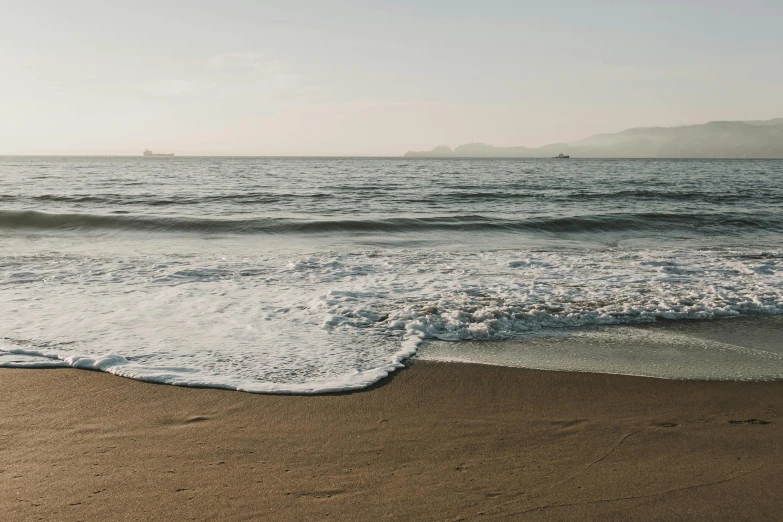 a man riding a surfboard on top of a sandy beach, by Carey Morris, unsplash contest winner, renaissance, photograph of san francisco, rippling water, sparsely populated, early evening