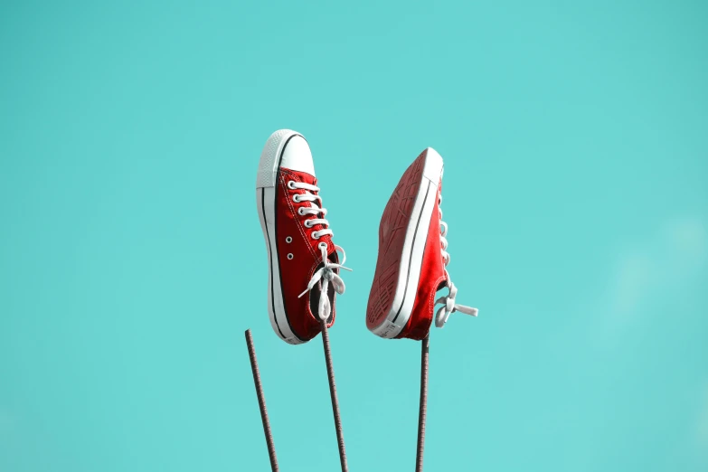 a pair of red sneakers sitting on top of a pole, pexels contest winner, magic realism, teal silver red, plain background, multiple stories, jets