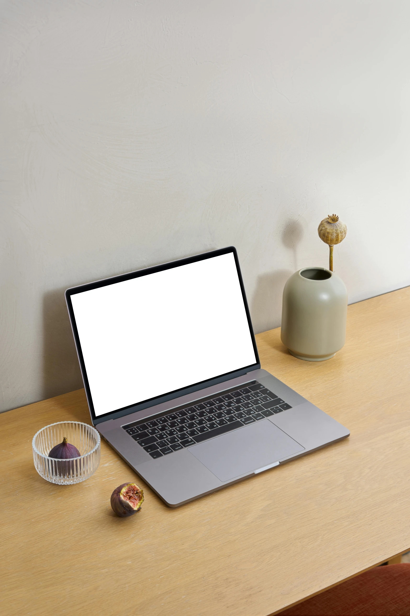 a laptop computer sitting on top of a wooden desk, pexels, rounded shapes, grey, creamy, plants