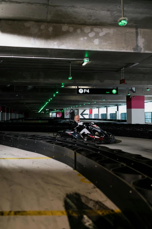 a person riding a motorcycle in a parking garage, bumper cars, neon pink and black color scheme, on a racetrack, thumbnail