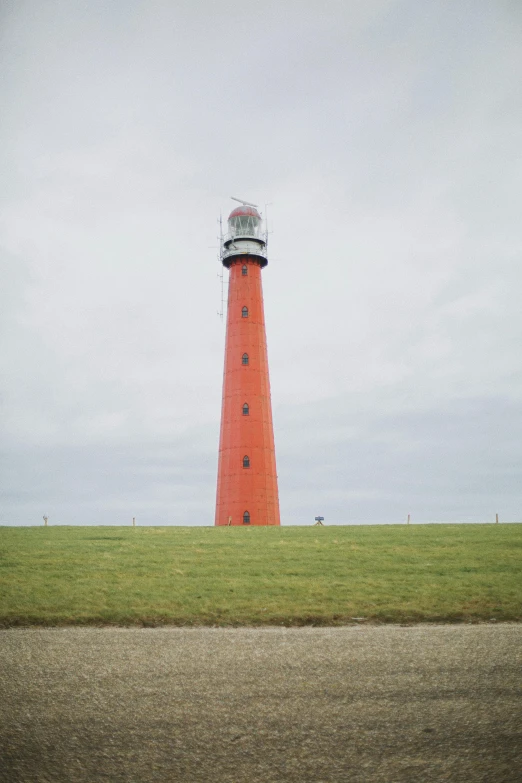 a red light house sitting on top of a lush green field, by Jan Tengnagel, a monumental, orange lamp, harbor, hyperminimalist