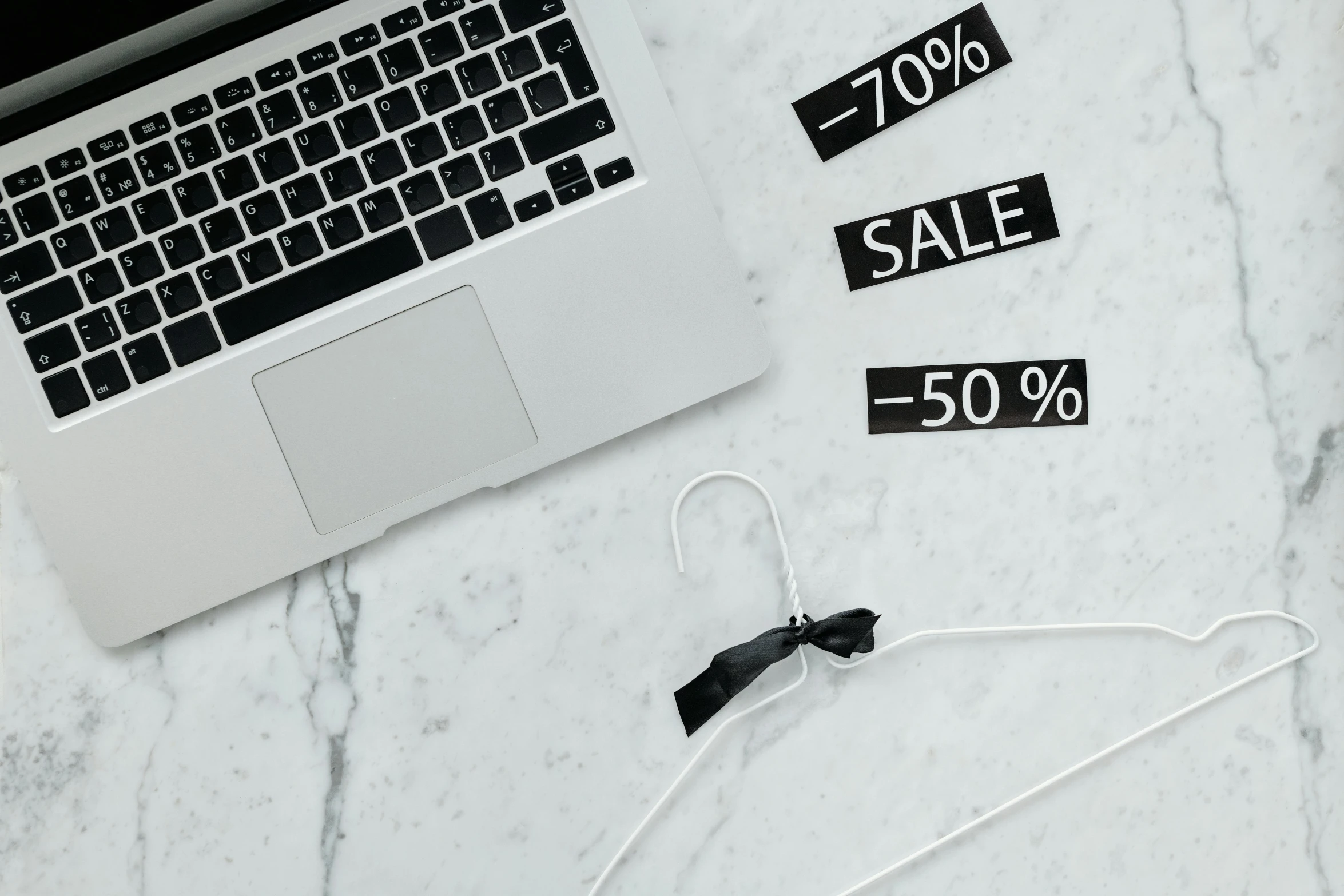 a laptop computer sitting on top of a marble table, sales, black and white clothes, bows, thumbnail