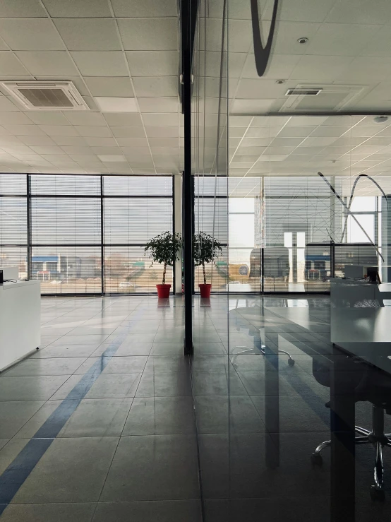 a room that has a table and chairs in it, by Jacob Toorenvliet, unsplash, light and space, inside of an auto dealership, lake view, office ceiling panels, cinematic very crisp