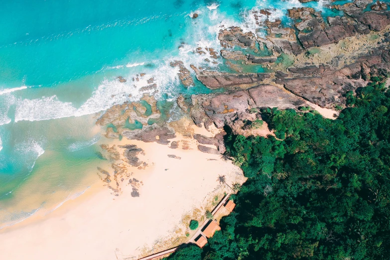 a large body of water next to a sandy beach, pexels contest winner, airborne view, luxurious onsens, rocky beach, sri lankan landscape